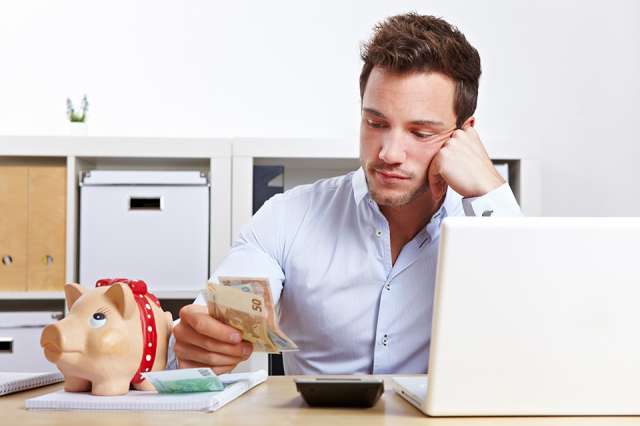 Mann mit Taschenrechner und Bargeld